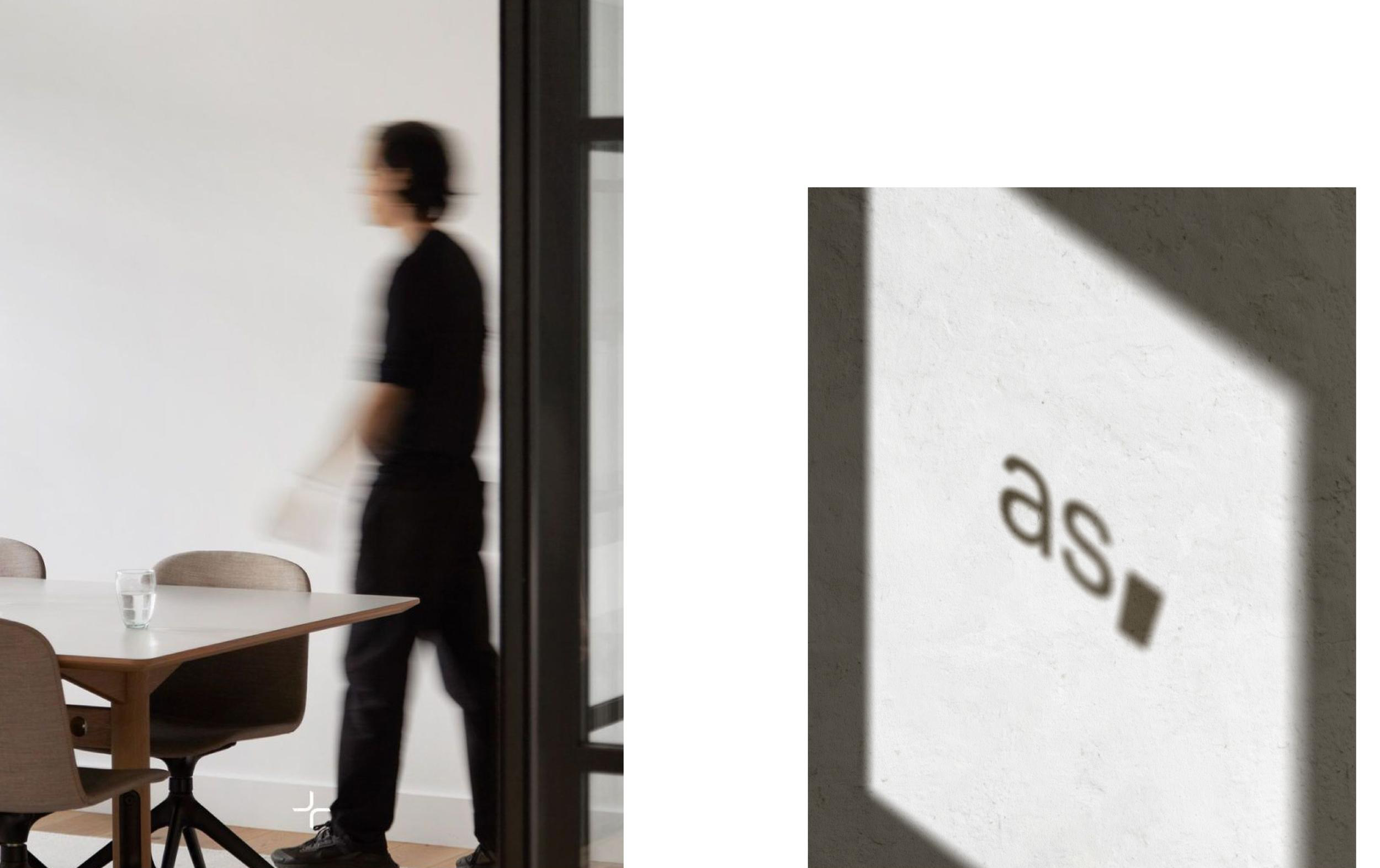 Architecturestudio office interior with a person walking and the logo etched on the wall